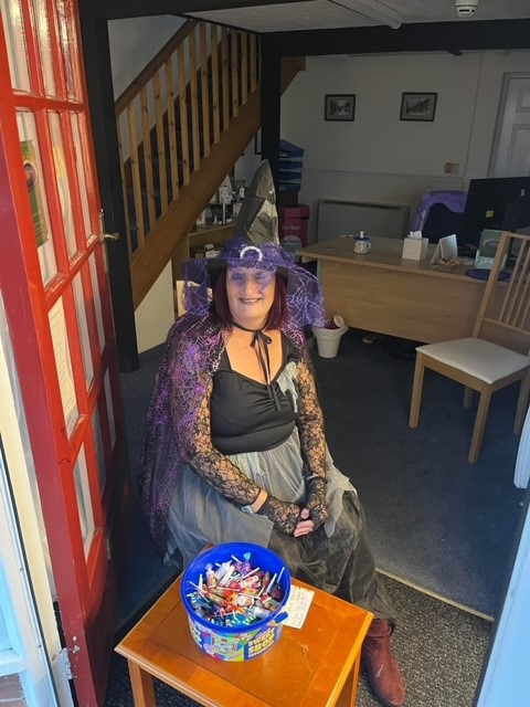 Sarah Graham giving out sweets while dressed up for Halloween.